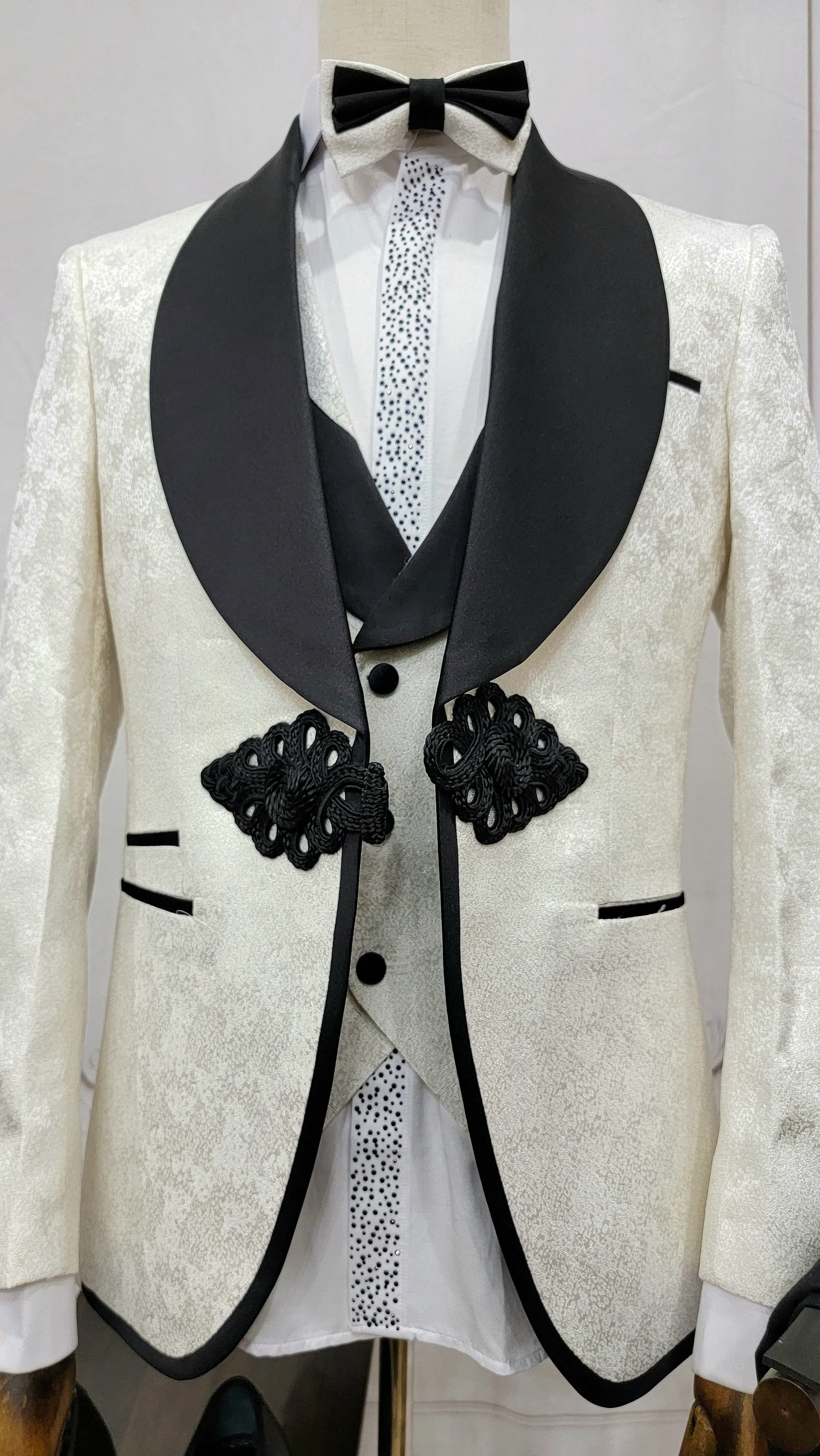 Three Piece Tuxedo Suit with Contrasting Black Lapel, matching bow tie and Black Pants. white knot
