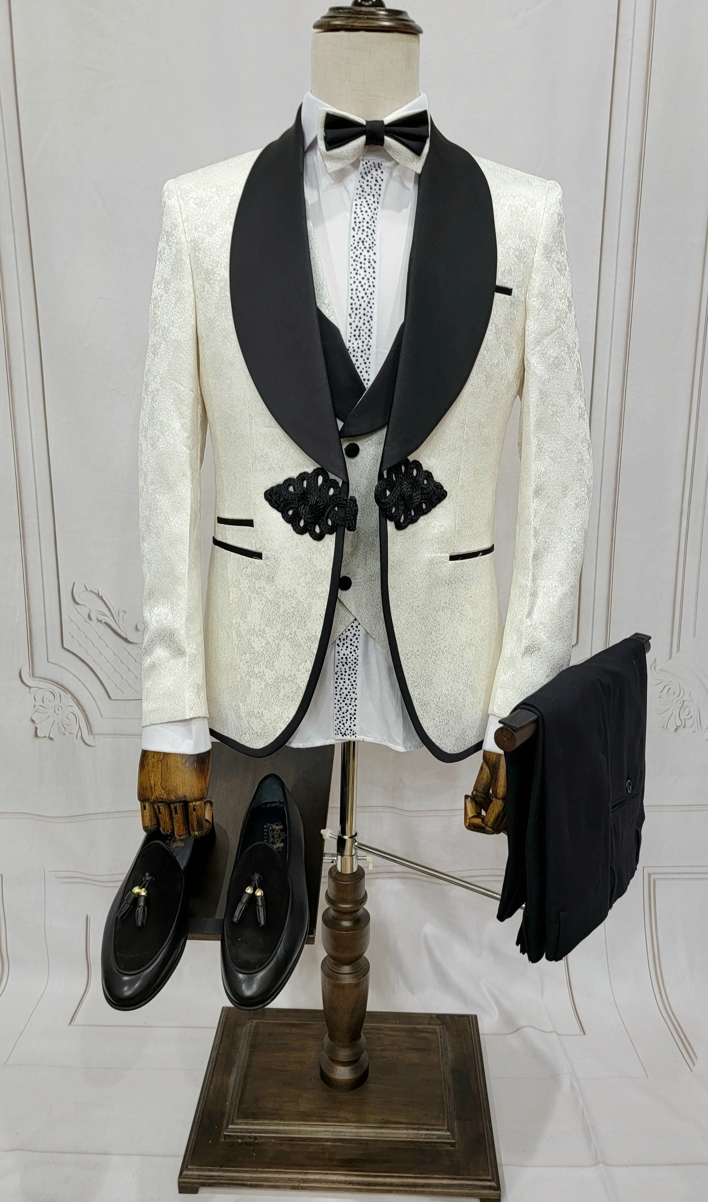 Three Piece Tuxedo Suit with Contrasting Black Lapel, matching bow tie and Black Pants. white knot